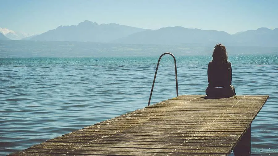 Frau am Steg am Wasser Meer sitzend traurig nachdenklich Weinend tot Tod müde niedergeschlagen sad